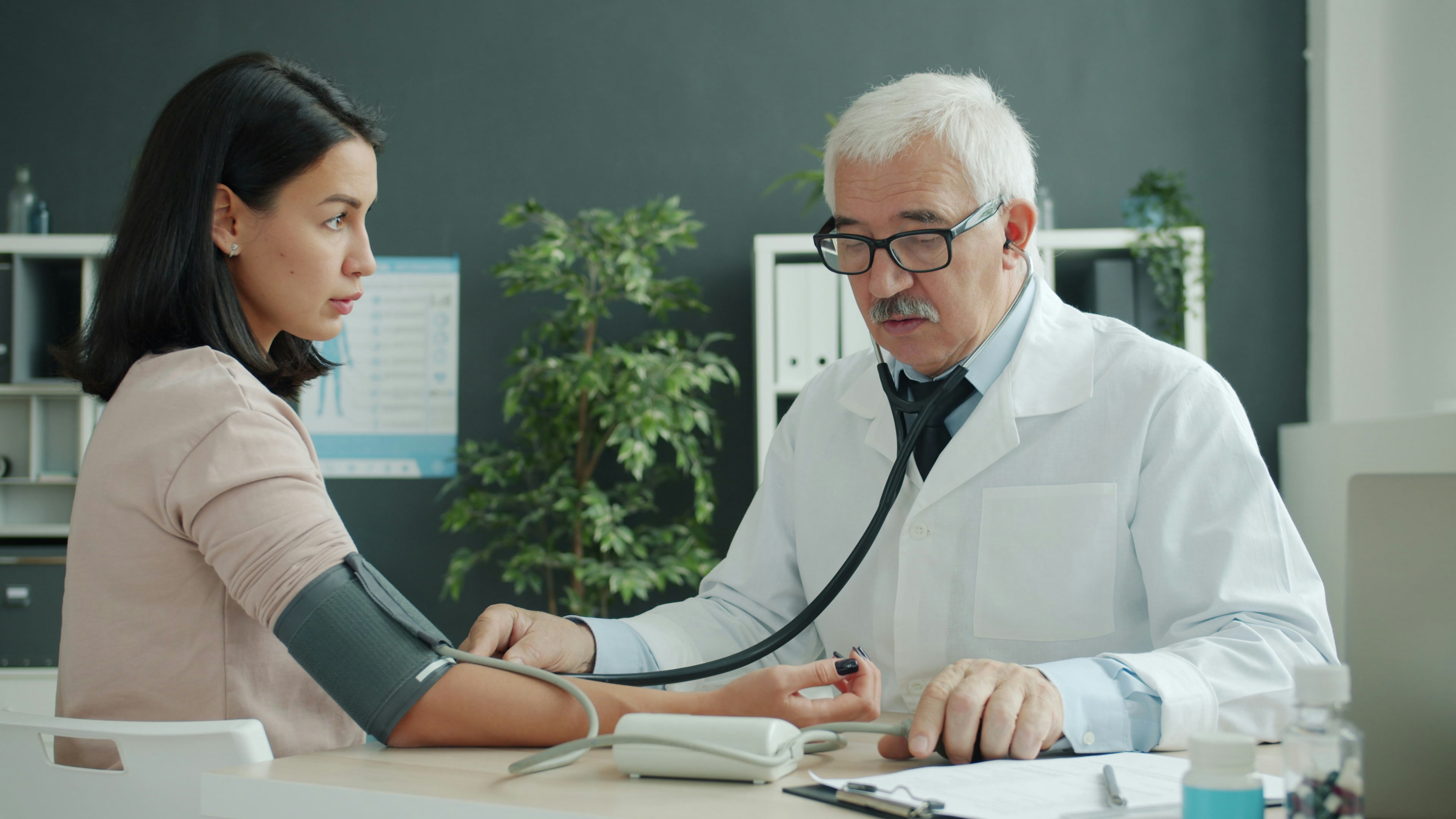 Atendimento de saude ocupacional com profissional revisando exames e prontuarios.